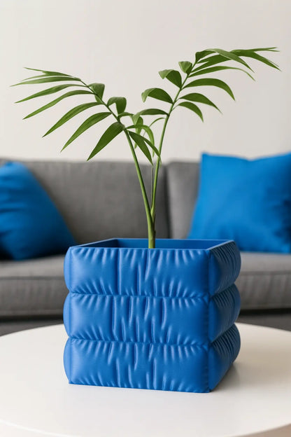 Doniczka do roślin do użytku wewnętrznego z wykończeniem o fakturze tkaniny.