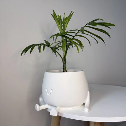 Kolorowa doniczka na kwiaty drukowana w technologii 3D z oczami i uśmiechniętą buzią.